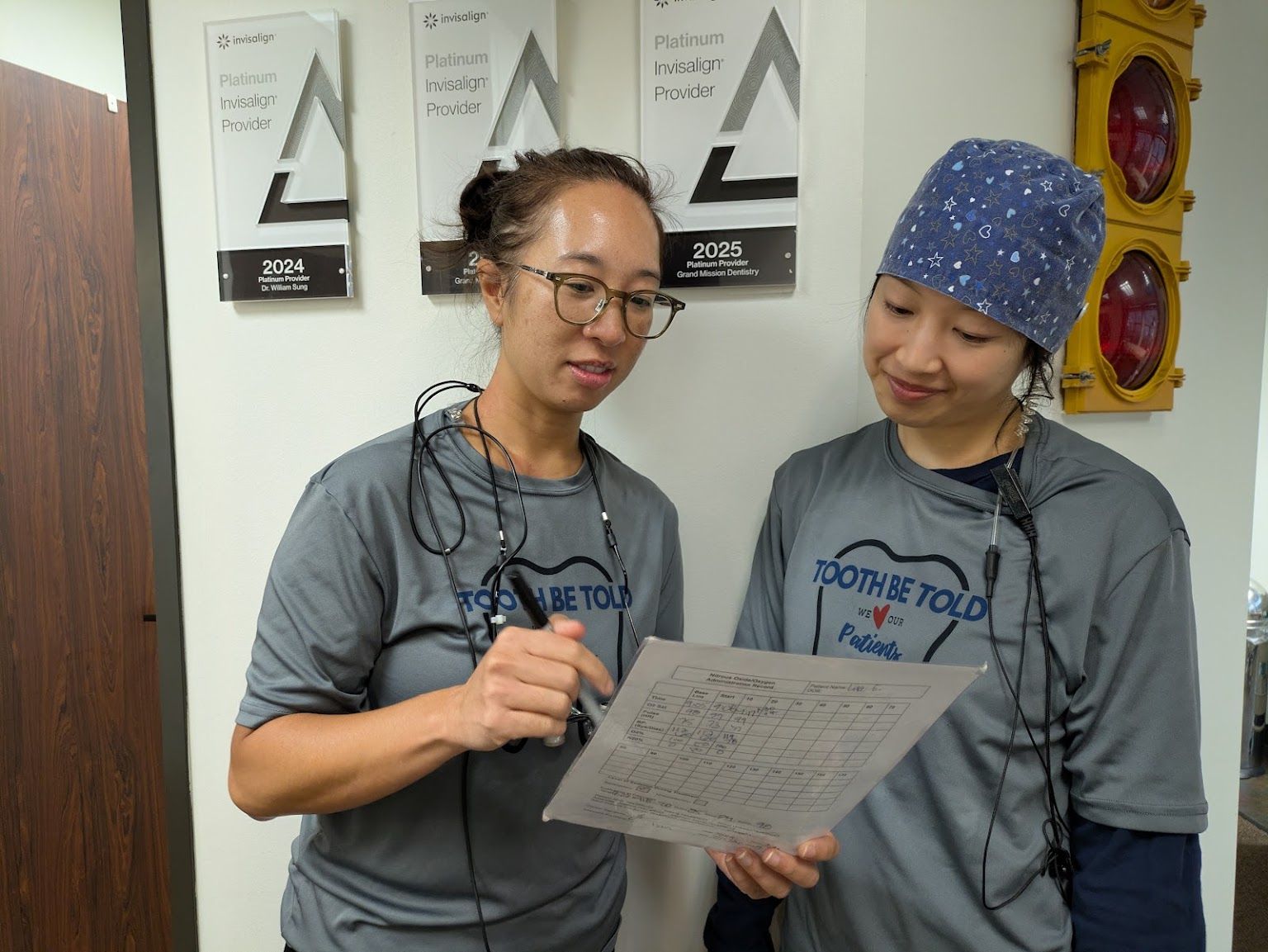Two of the team reading a schedule under the award plaques