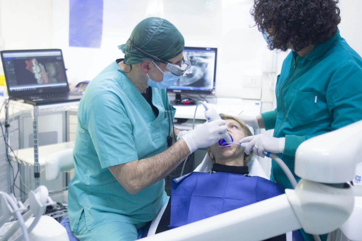 Two clinicians at work over a patient