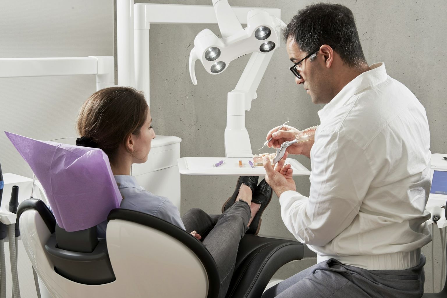 A patient reclined and at ease while the dentist prepares