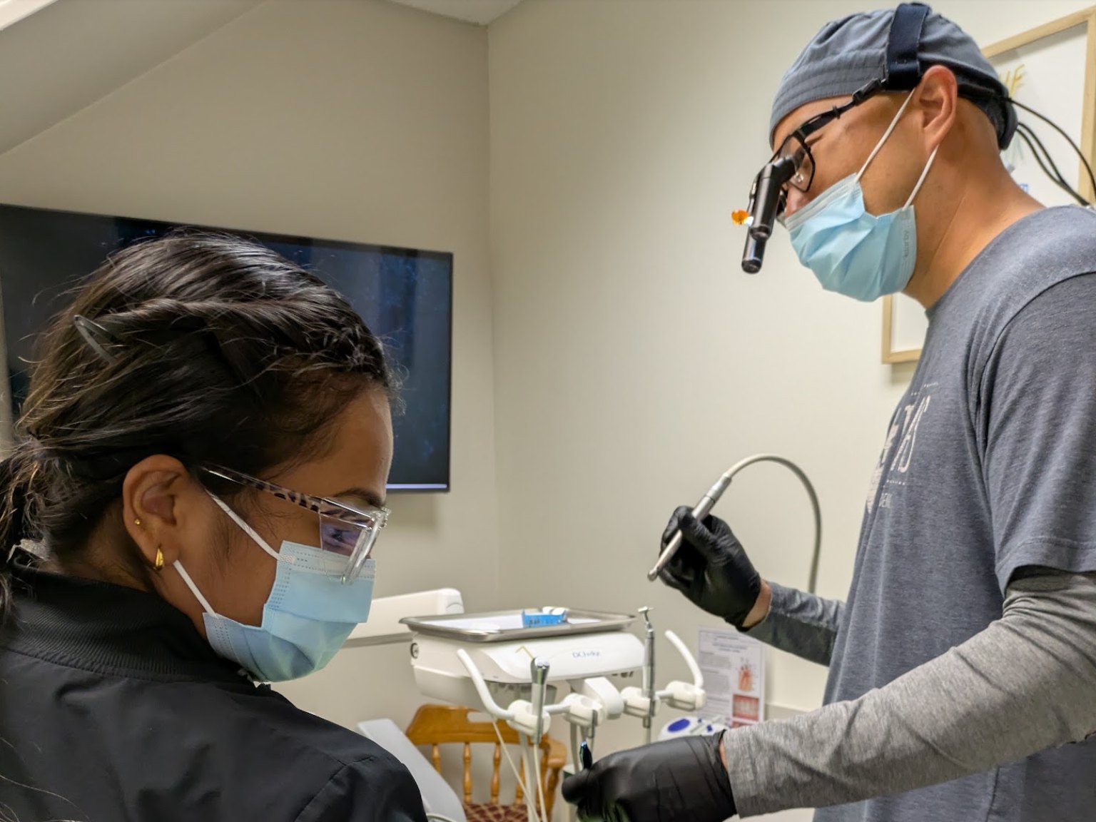 The dentist and an assistant at the chair during a visit