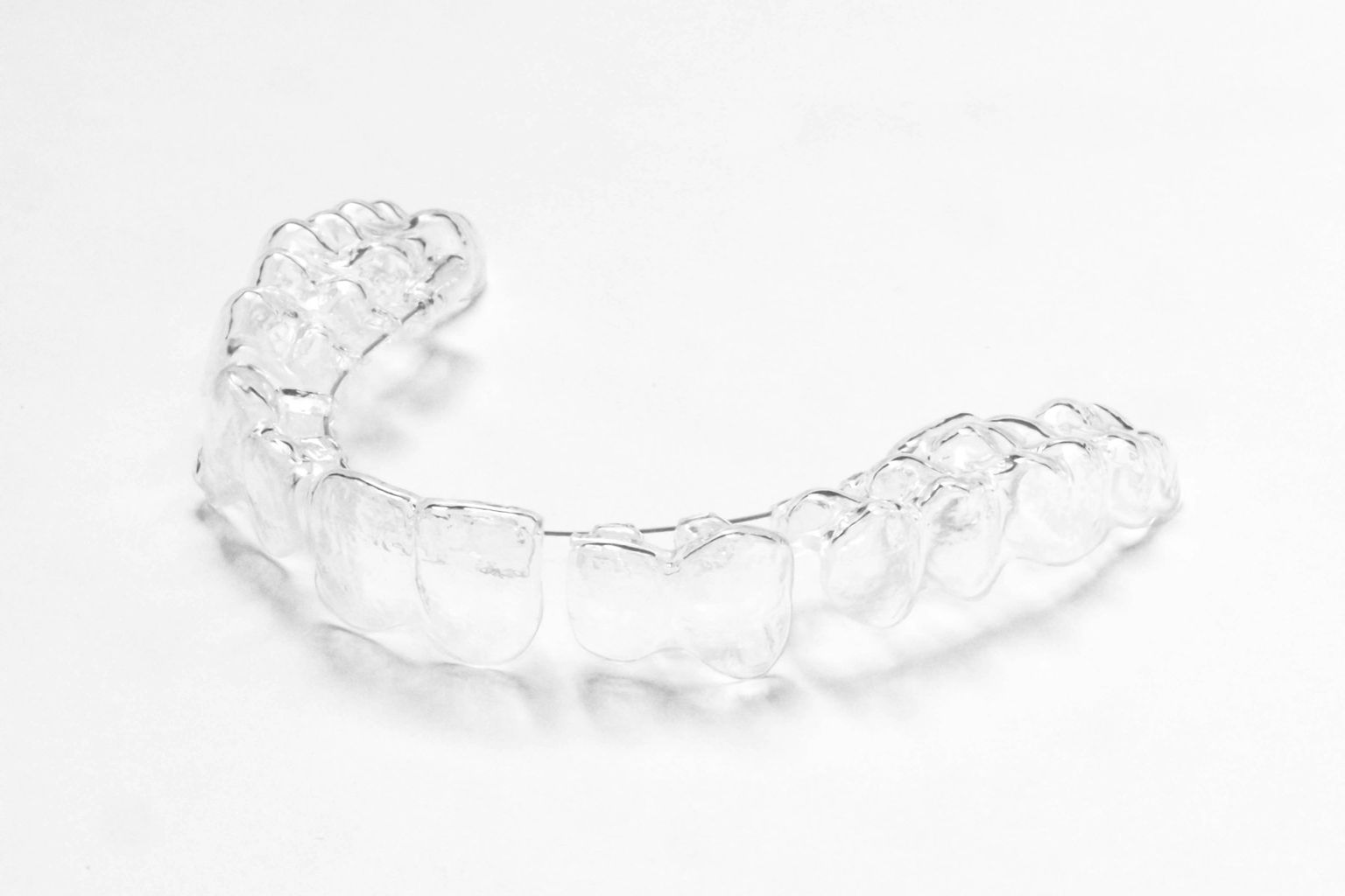 A clear aligner on a white surface