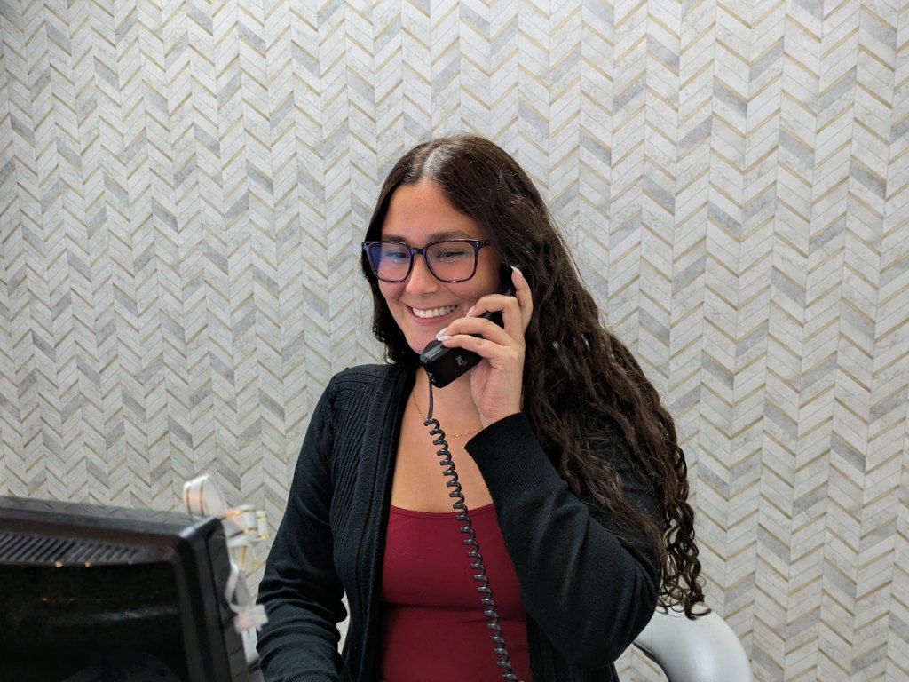 A member of the front desk booking a visit by phone