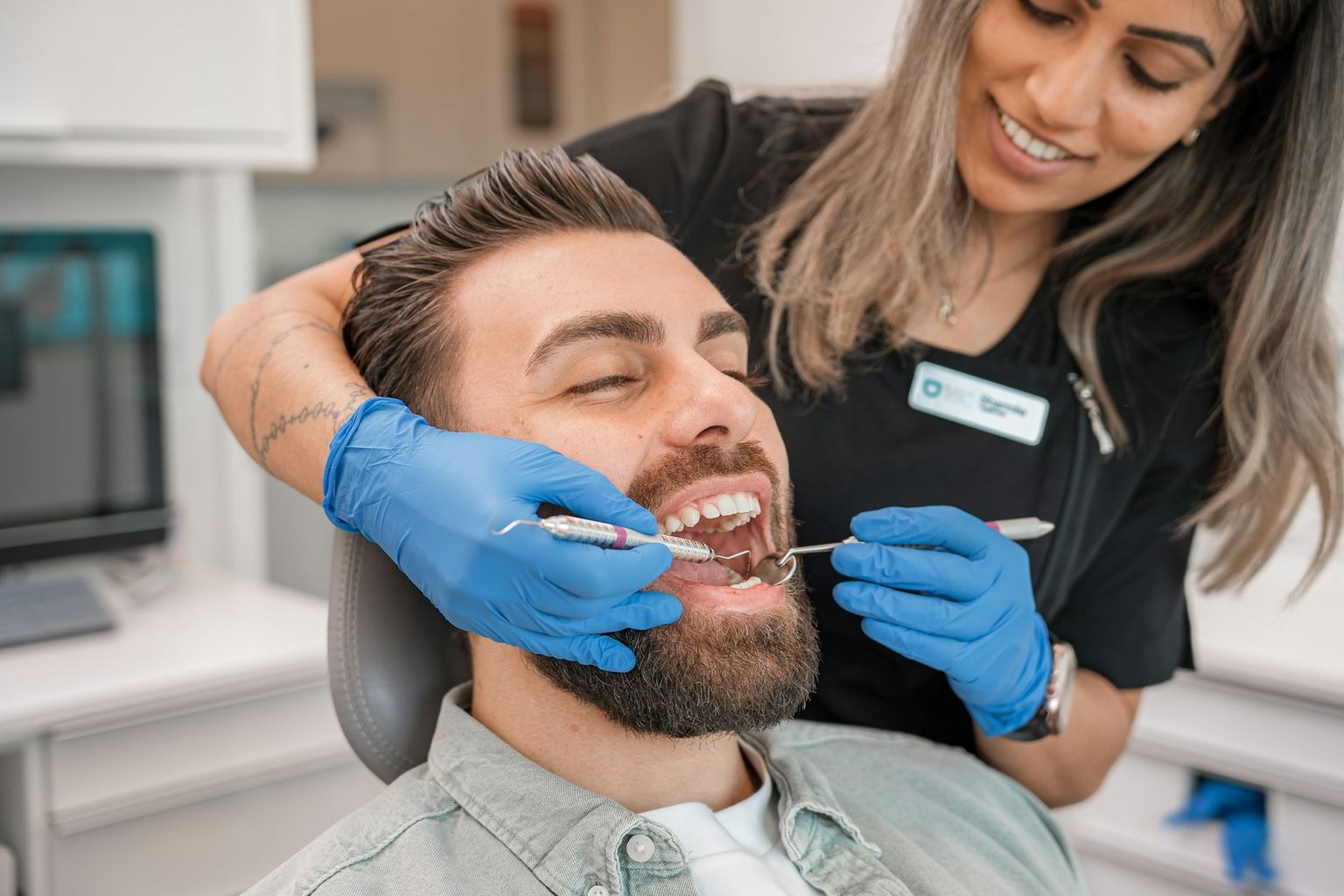 A dentist examining a smiling patient