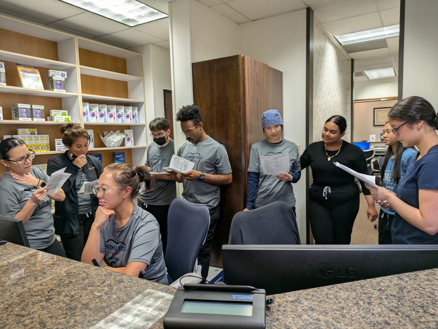 The whole team at the front desk, reading the day's schedule