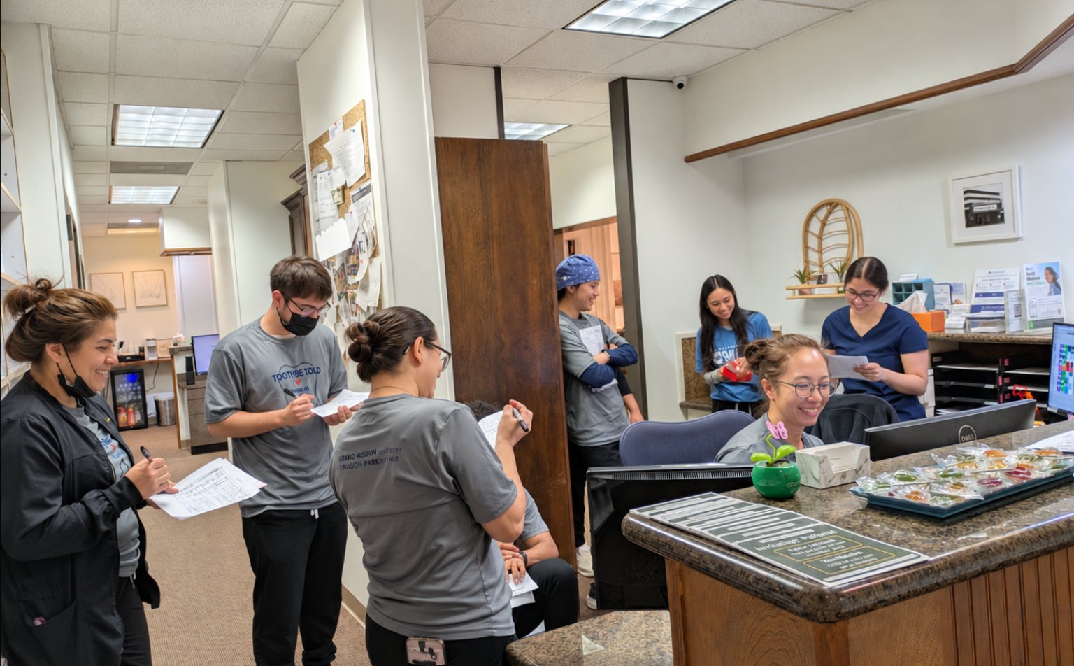 The team at the front desk with the corridor to the treatment rooms behind them