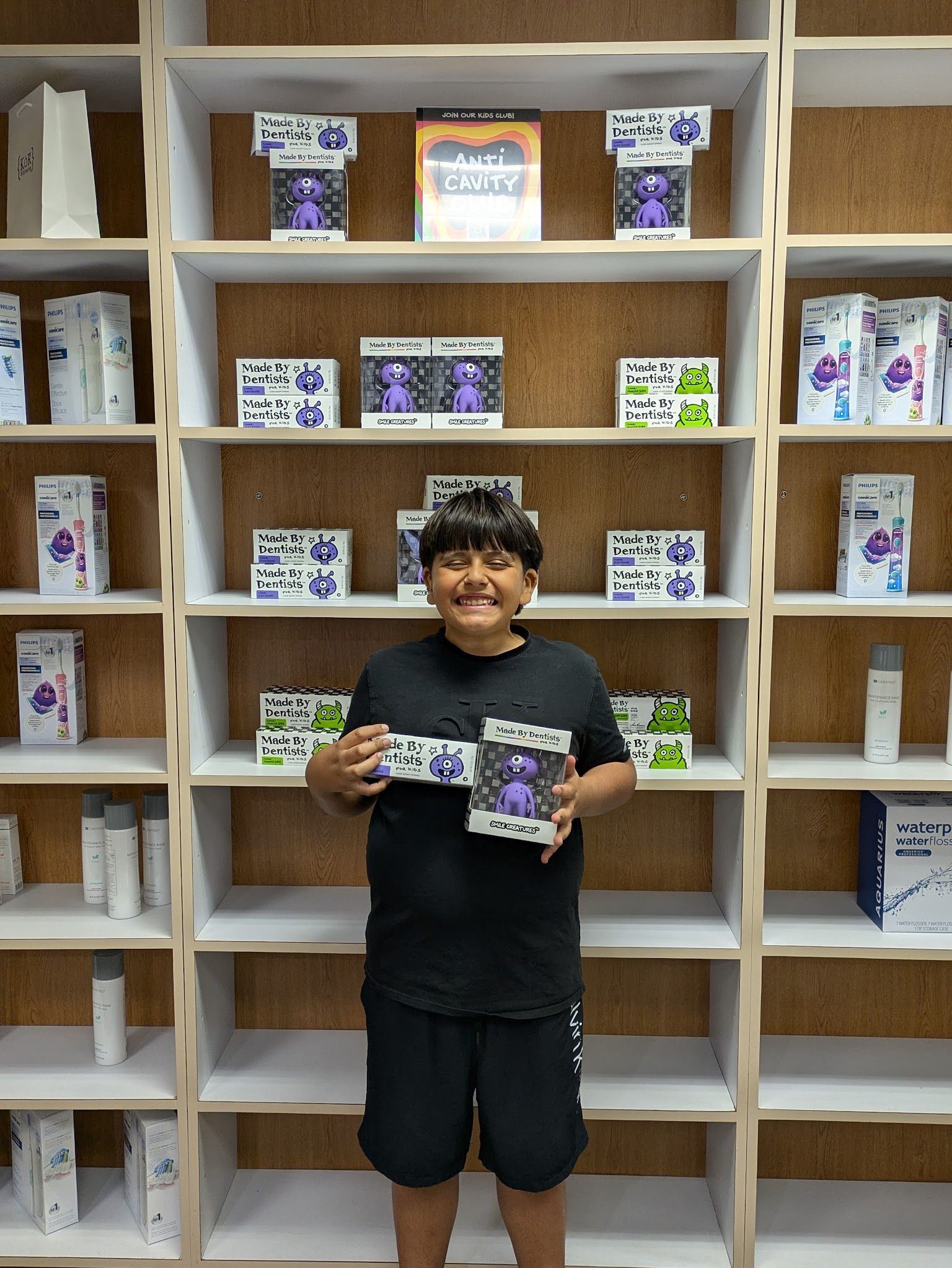 A young patient holding a take-home kit at the front desk